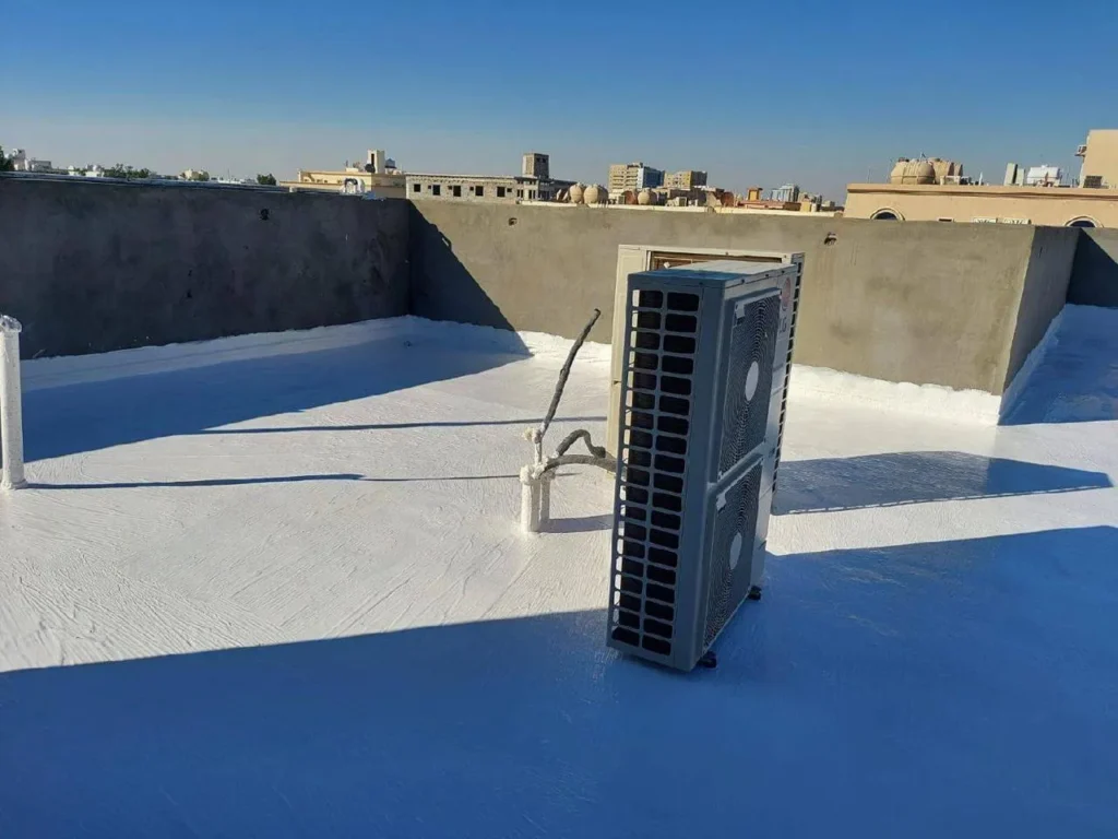 وحدة تكييف هواء موضوعة على سطح مبنى مغطى بطلاء عازل أبيض عاكس للحرارة