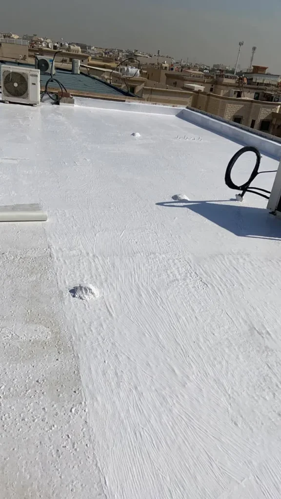 تنفيذ عزل أسطح مائي أبيض فوق سطح مبنى، مع معالجة الفواصل وبروزات المواسير، ووجود وحدات تكييف خارجية